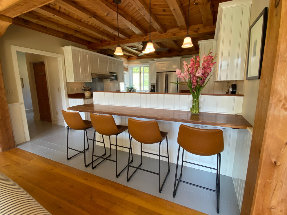 Idéer för att renovera ett stort minimalistiskt brun brunt kök och matrum, med en enkel diskho, skåp i shakerstil, gula skåp, träbänkskiva, rostfria vitvaror, målat trägolv och grått golv