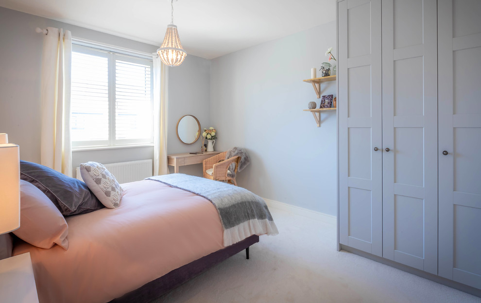 Inspiration for a mid-sized beach style master bedroom in Hampshire with grey walls, carpet and white floor.