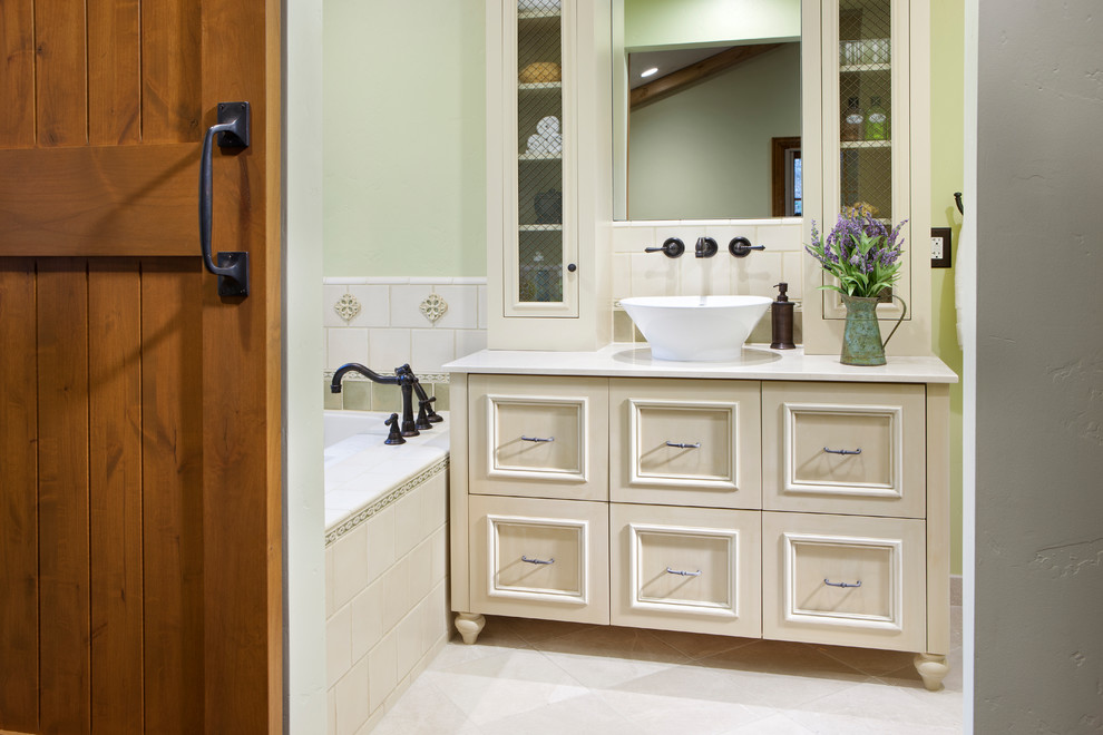 Photo of a small country master bathroom in Sacramento with furniture-like cabinets, beige cabinets, an undermount tub, a two-piece toilet, multi-coloured tile, porcelain tile, green walls, marble floors, a vessel sink and marble benchtops.