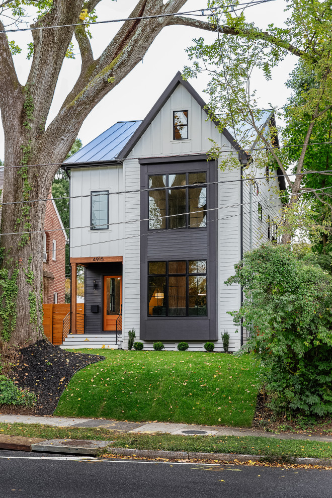 This is an example of a large farmhouse house exterior in DC Metro with three floors and concrete fibreboard cladding.