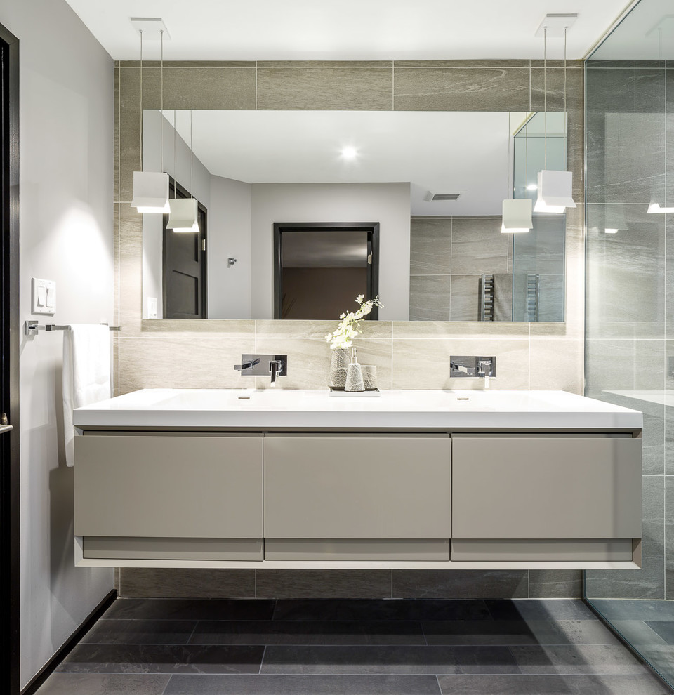 This is an example of a large contemporary master bathroom in Ottawa with flat-panel cabinets, grey cabinets, a corner tub, an open shower, a two-piece toilet, gray tile, grey walls and a drop-in sink.
