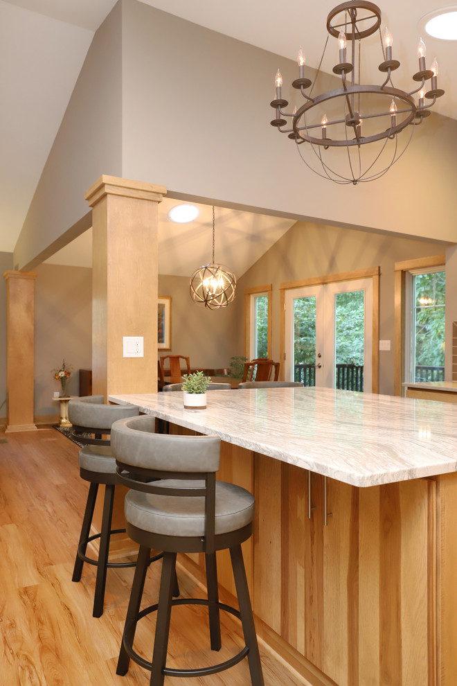 Mid-sized transitional u-shaped light wood floor and brown floor eat-in kitchen photo in Grand Rapids with an undermount sink, flat-panel cabinets, light wood cabinets, quartz countertops, brown backsplash, ceramic backsplash, stainless steel appliances and an island
