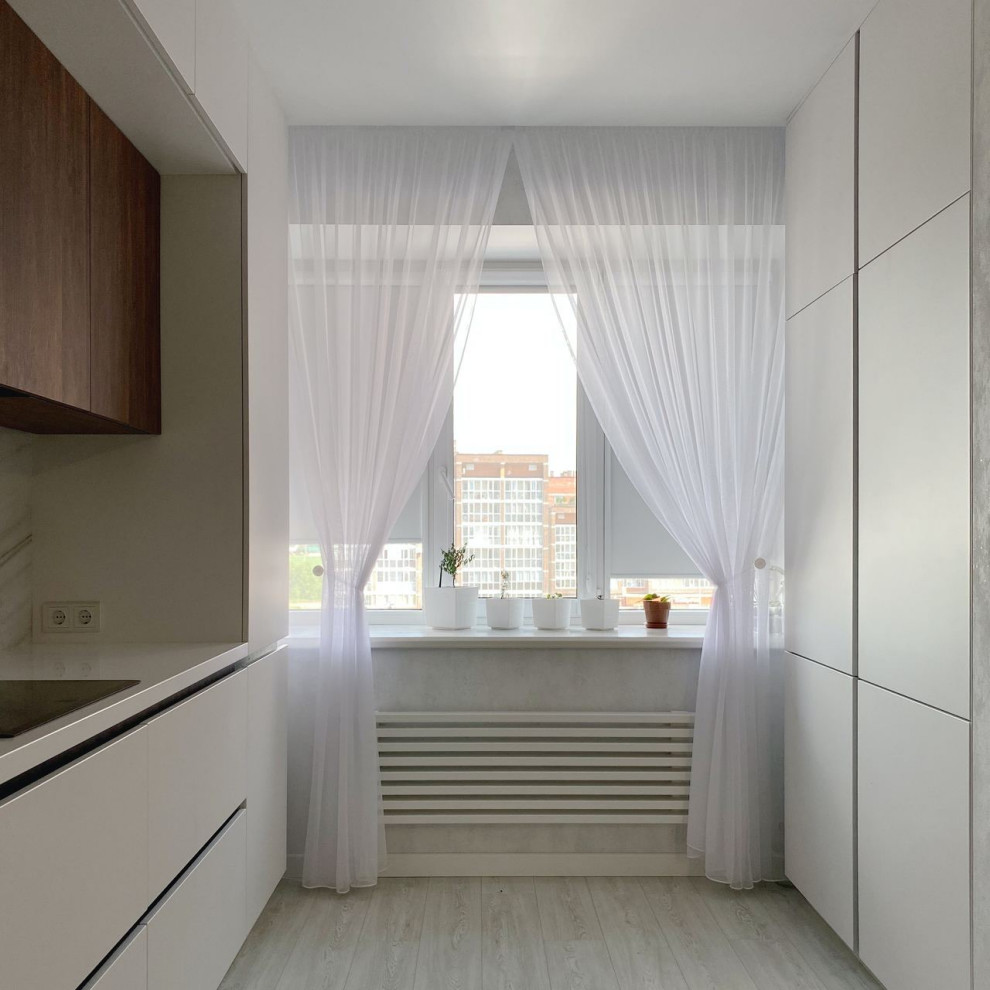 Exempel på ett stort modernt vit vitt kök, med en integrerad diskho, släta luckor, vita skåp, bänkskiva i koppar, grått stänkskydd, stänkskydd i porslinskakel, svarta vitvaror, laminatgolv och turkost golv