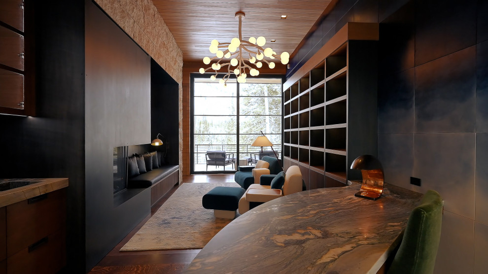 Inspiration för ett litet funkis hemmabibliotek, med flerfärgade väggar, mellanmörkt trägolv, en bred öppen spis, ett fristående skrivbord och brunt golv