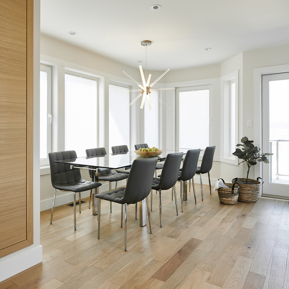 Photo of a small scandinavian dining room in Vancouver with white walls, light hardwood floors, no fireplace and beige floor.