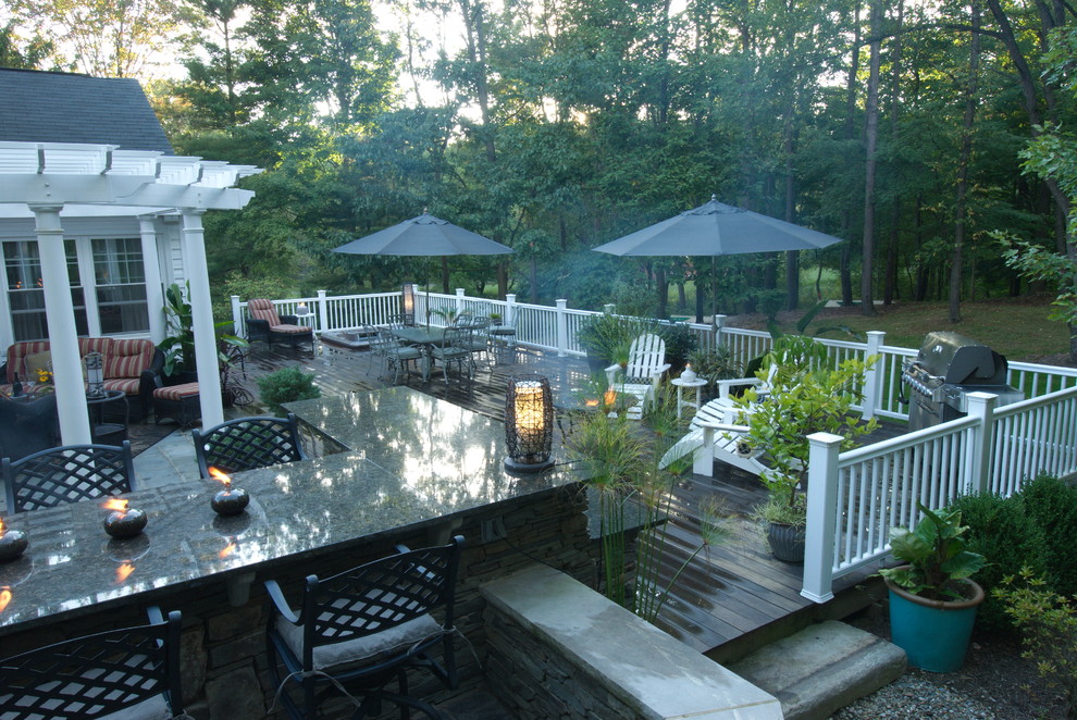 This is an example of a traditional backyard deck in Cleveland with a fire feature and a pergola.