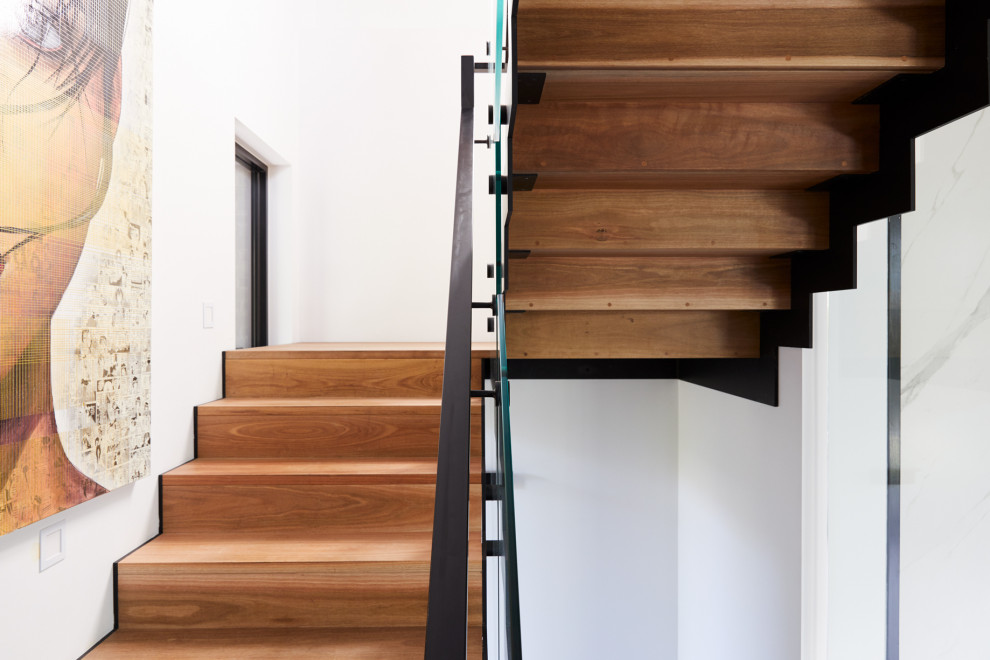 На фото: большая п-образная деревянная лестница в стиле лофт с деревянными ступенями и металлическими перилами