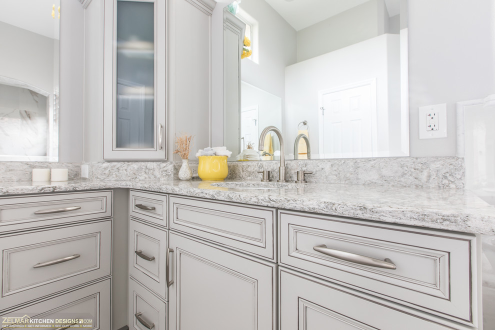 Inspiration for a mid-sized transitional master bathroom in Orlando with recessed-panel cabinets, grey cabinets, a freestanding tub, a corner shower, gray tile, porcelain tile, grey walls, porcelain floors, an undermount sink, engineered quartz benchtops, grey floor and multi-coloured benchtops.