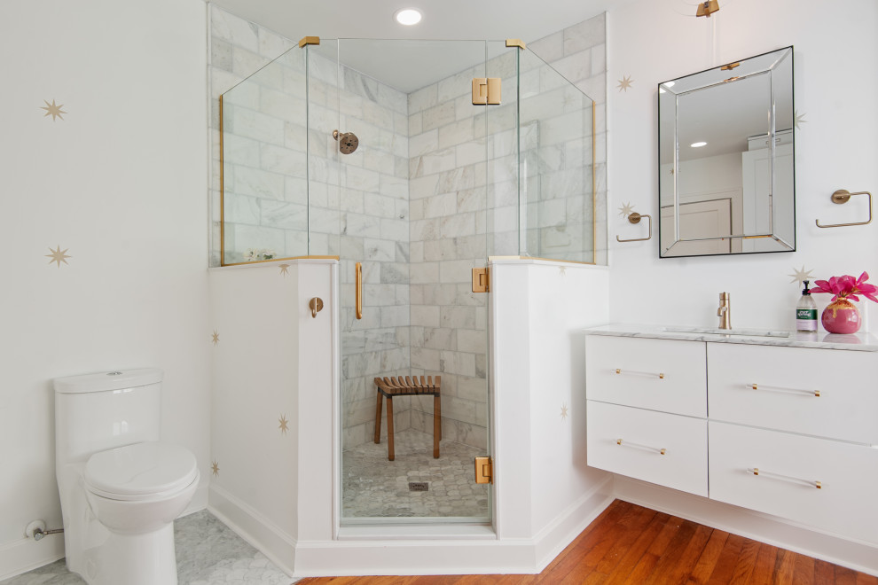 Mid-sized traditional master bathroom in Tampa with shaker cabinets, white cabinets, a corner shower, a two-piece toilet, yellow tile, porcelain tile, white walls, medium hardwood floors, an undermount sink, quartzite benchtops, brown floor, a hinged shower door and grey benchtops.