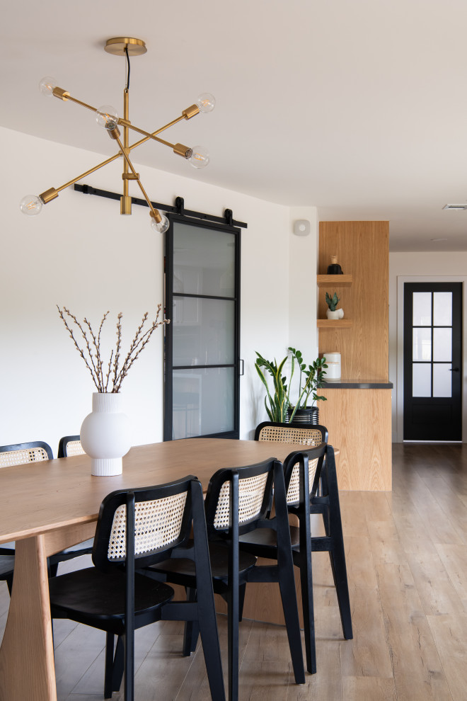 Cette image montre une salle à manger ouverte sur la cuisine marine de taille moyenne avec un sol en bois brun.