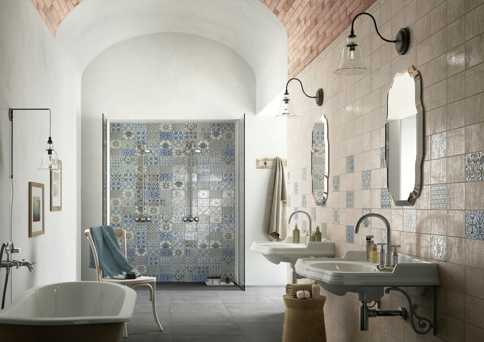 Large mediterranean master bathroom in Copenhagen with a freestanding tub, a double shower, a wall-mount sink, multi-coloured tile, ceramic tile, multi-coloured walls and concrete floors.