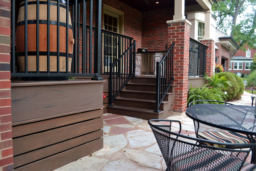 Photo of a large eclectic back ground level metal railing terrace in St Louis with a fireplace and a roof extension.