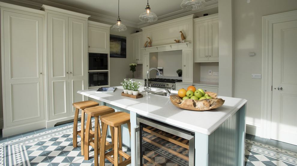 Mid-sized country l-shaped eat-in kitchen in Dublin with quartzite benchtops, ceramic floors, an undermount sink, shaker cabinets, white cabinets, beige splashback, stone slab splashback, stainless steel appliances, a peninsula and multi-coloured floor.