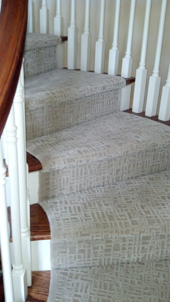 This is an example of a large transitional carpeted staircase in Philadelphia with carpet risers.