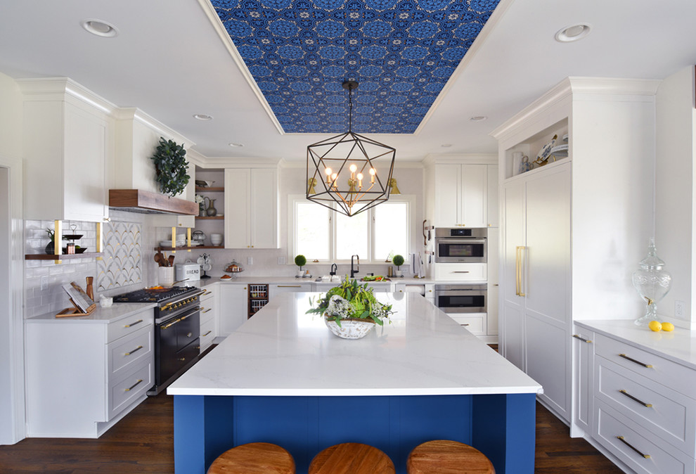 Inspiration for a transitional u-shaped medium tone wood floor and brown floor eat-in kitchen remodel in Cincinnati with shaker cabinets, white cabinets, white backsplash, paneled appliances, an island and white countertops