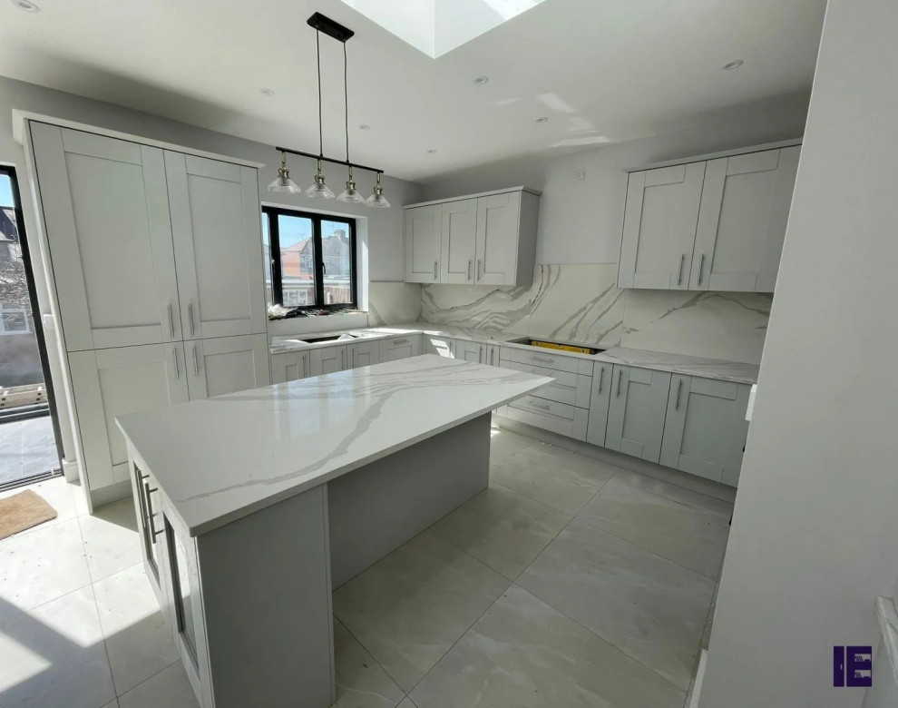 Photo of a large contemporary u-shaped kitchen/diner in London with a single-bowl sink, shaker cabinets, grey cabinets, quartz worktops, grey splashback, a breakfast bar, grey worktops and feature lighting.
