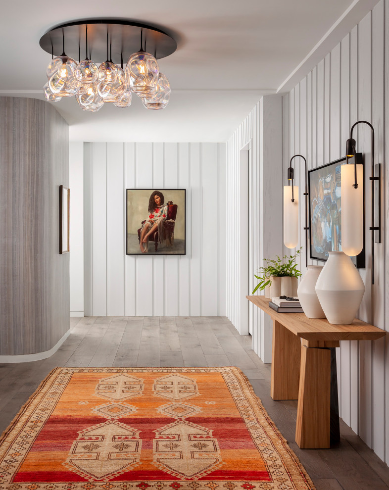 Hallway - contemporary light wood floor and wall paneling hallway idea in Austin with white walls