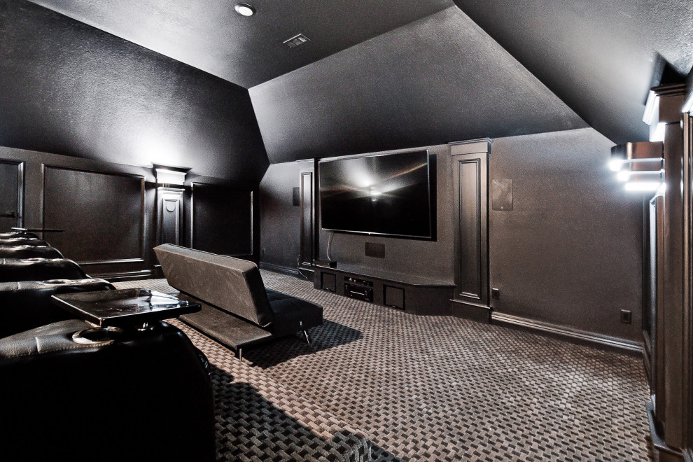 Inredning av ett klassiskt stort avskild hemmabio, med svarta väggar, heltäckningsmatta, en väggmonterad TV och svart golv