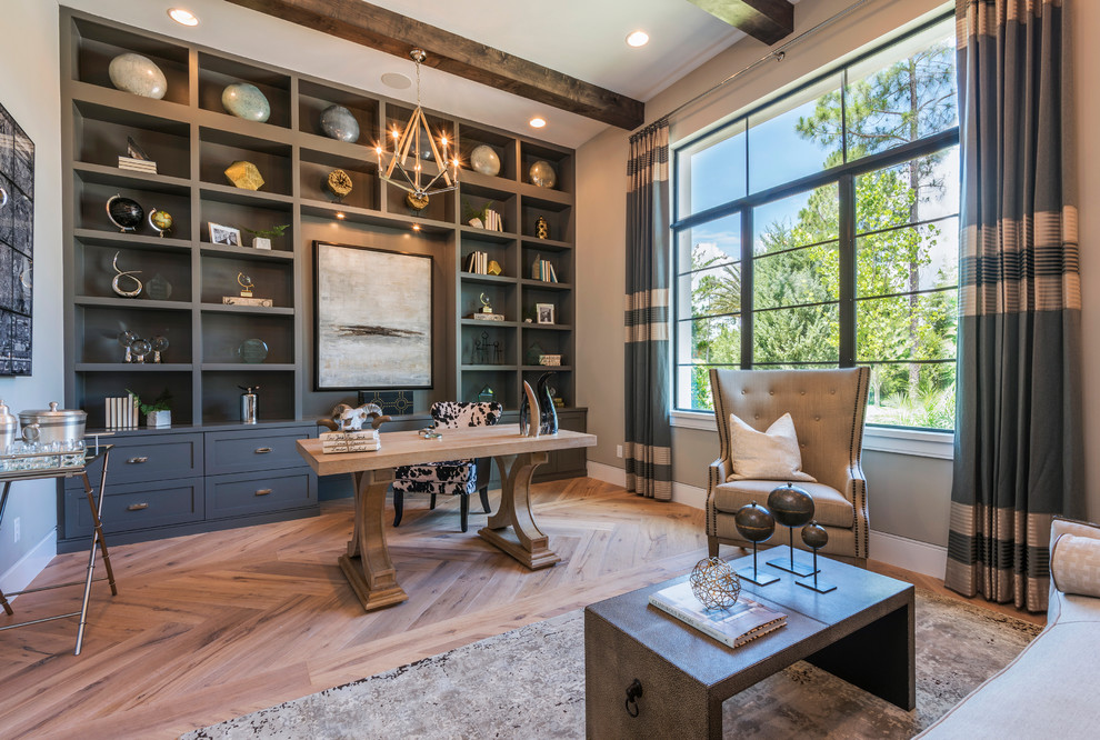 This is an example of a transitional study room in Orlando with beige walls, medium hardwood floors, a freestanding desk, beige floor and exposed beam.