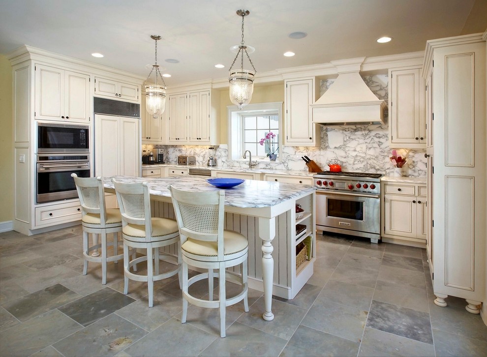 Traditional eat-in kitchen in Milwaukee with panelled appliances, white cabinets, marble benchtops, ceramic floors, with island and marble splashback.