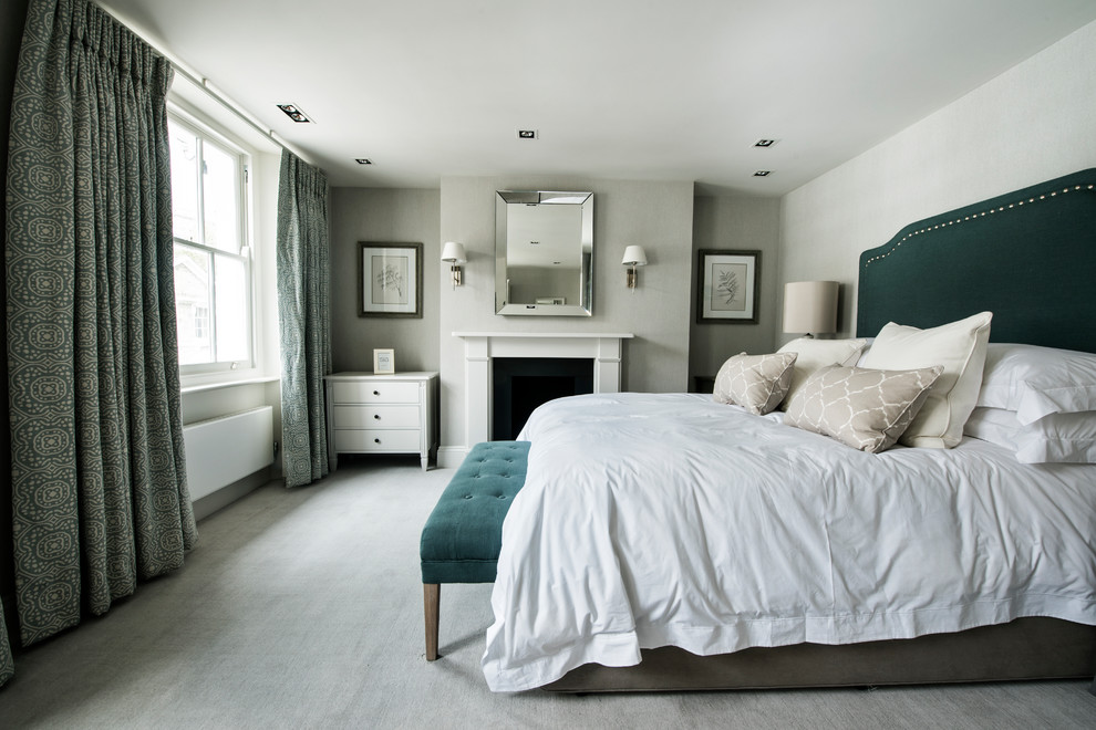 Inspiration for a mid-sized transitional bedroom in London with grey walls, grey floor, carpet and a standard fireplace.