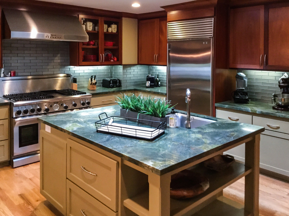 Inspiration for a mid-sized transitional u-shaped medium tone wood floor kitchen remodel with an undermount sink, shaker cabinets, medium tone wood cabinets, granite countertops, blue backsplash, glass tile backsplash, stainless steel appliances and an island