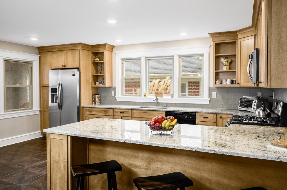Design ideas for a mid-sized arts and crafts u-shaped eat-in kitchen in Philadelphia with an undermount sink, shaker cabinets, light wood cabinets, granite benchtops, glass tile splashback, grey splashback, black appliances, linoleum floors and a peninsula.