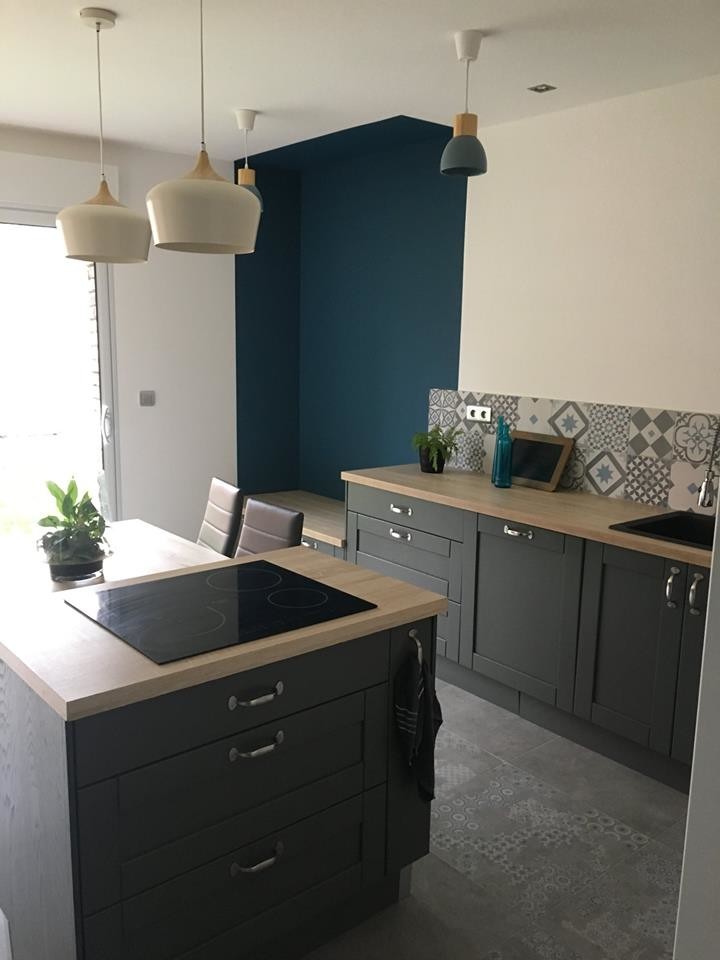 Photo of a mid-sized country galley open plan kitchen in Lille with an integrated sink, laminate benchtops, grey splashback, cement tile splashback, panelled appliances, ceramic floors, with island, grey floor and brown benchtop.
