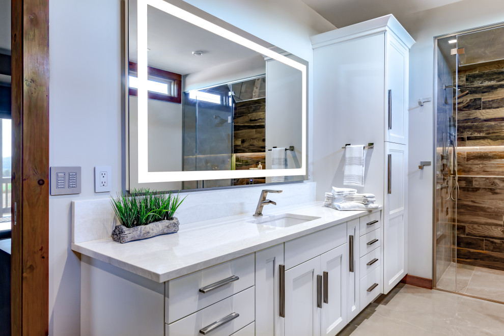 Inredning av ett klassiskt mellanstort vit vitt en-suite badrum, med luckor med infälld panel, grå skåp, ett fristående badkar, en kantlös dusch, en bidé, brun kakel, grå väggar, klinkergolv i porslin, ett undermonterad handfat, bänkskiva i kvarts, grått golv och dusch med gångjärnsdörr