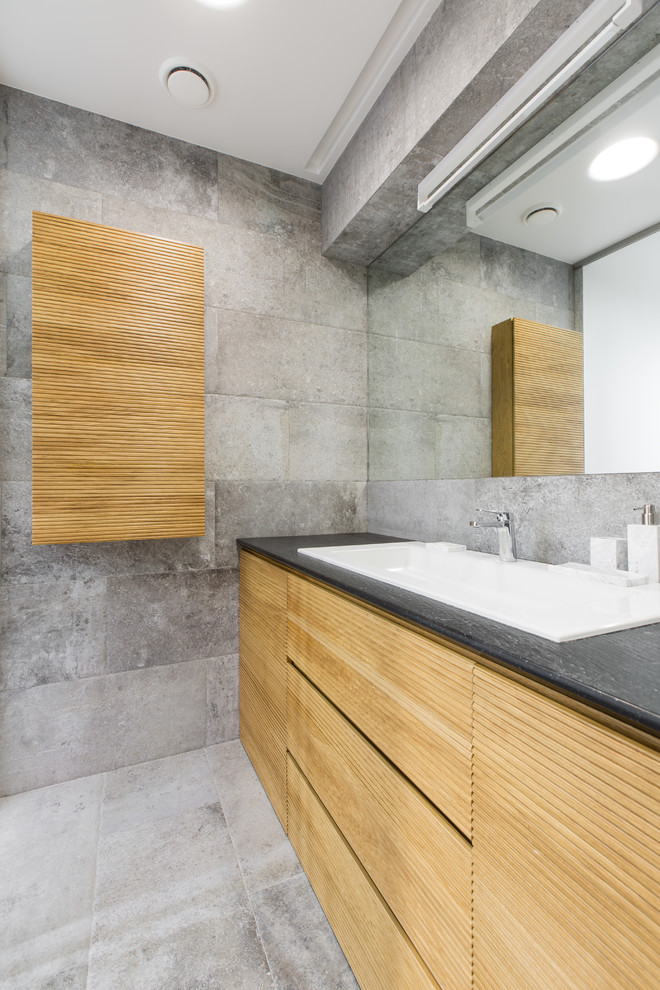 Photo of a mid-sized scandinavian 3/4 bathroom in Moscow with light wood cabinets, gray tile, porcelain tile, porcelain floors, engineered quartz benchtops, a drop-in sink, grey walls and flat-panel cabinets.