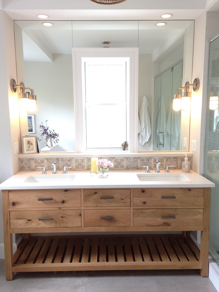 Photo of a mid-sized country master bathroom in Chicago with furniture-like cabinets, light wood cabinets, an alcove shower, a one-piece toilet, multi-coloured tile, terra-cotta tile, grey walls, porcelain floors, an undermount sink, engineered quartz benchtops, grey floor, a hinged shower door and white benchtops.