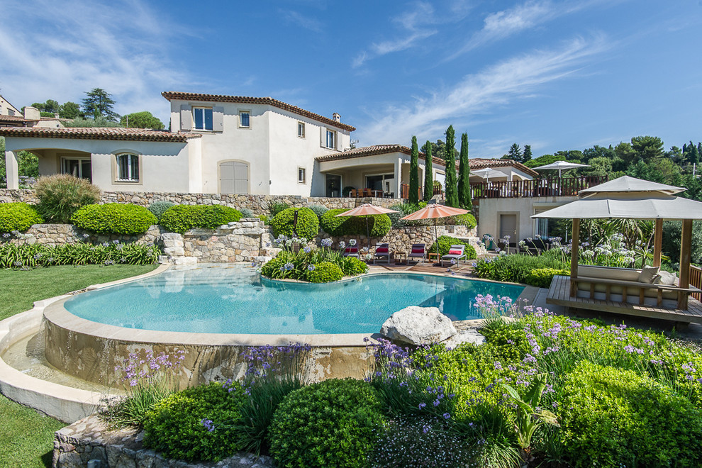 Design ideas for a mid-sized mediterranean backyard custom-shaped pool in Nice.