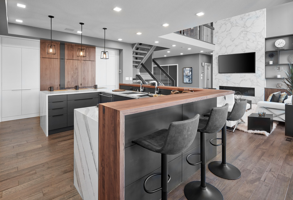 Design ideas for a large contemporary u-shaped eat-in kitchen in Edmonton with an undermount sink, louvered cabinets, white cabinets, wood benchtops, grey splashback, porcelain splashback, stainless steel appliances, medium hardwood floors, with island, brown floor and brown benchtop.