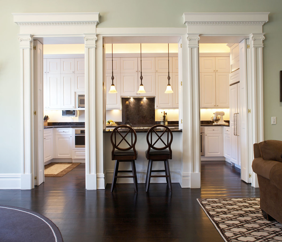 Photo of a large traditional eat-in kitchen in New York with white splashback and dark hardwood floors.