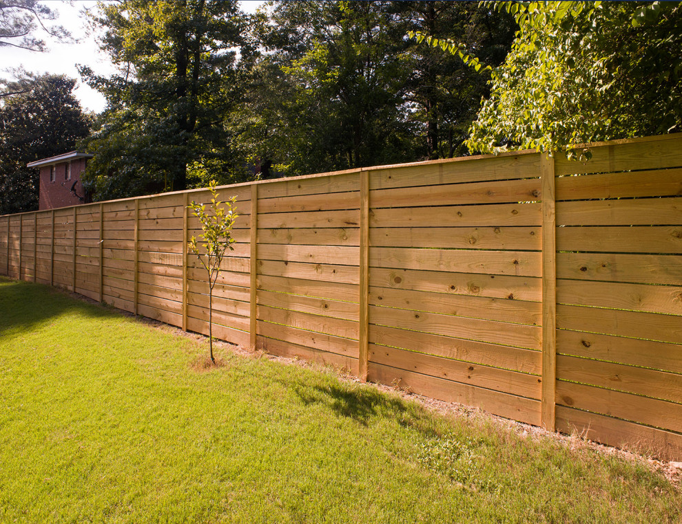 Aménagement d'un jardin arrière classique avec une clôture en bois.