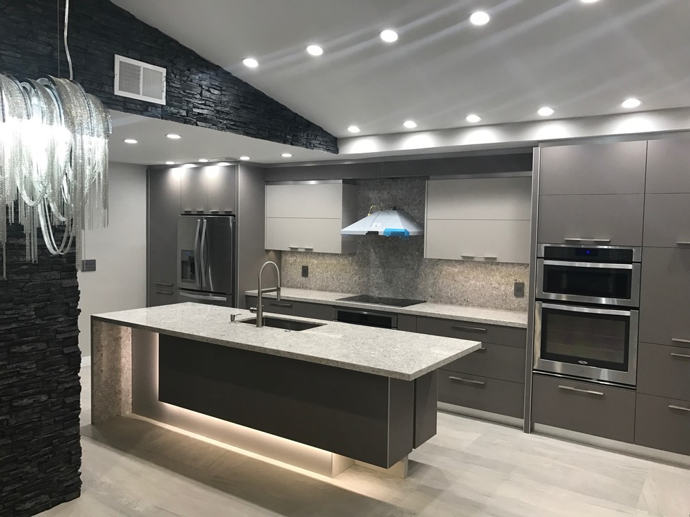 This is an example of a mid-sized modern l-shaped kitchen pantry in Miami with a drop-in sink, grey cabinets, quartzite benchtops, beige splashback, limestone splashback, stainless steel appliances, marble floors, with island, beige floor and white benchtop.