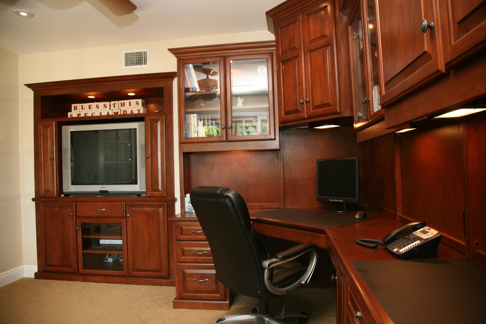 This is an example of a large traditional study room in Orange County with beige walls, carpet and a built-in desk.