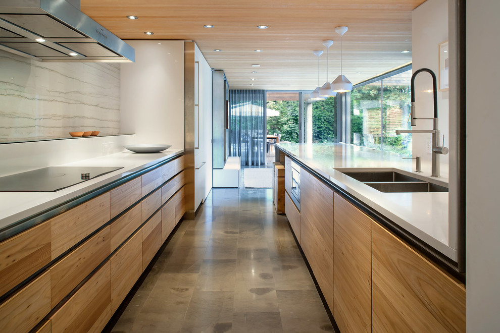 Inspiration for an expansive modern kitchen in Vancouver with an undermount sink, flat-panel cabinets, white cabinets, quartz benchtops, white splashback, stone slab splashback, panelled appliances, limestone floors and with island.