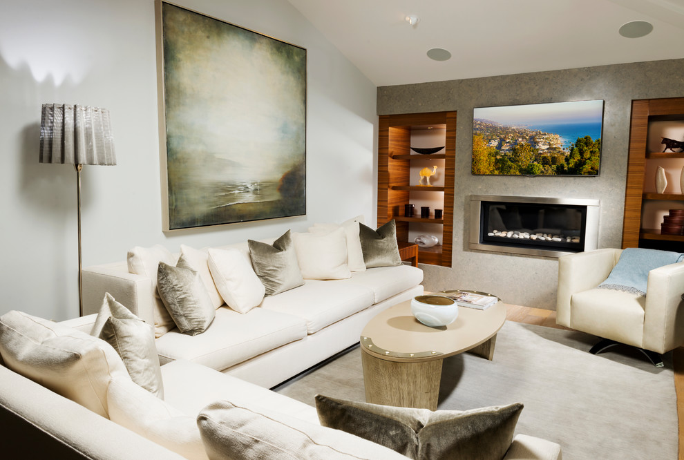 Photo of a mid-sized contemporary enclosed living room in Orange County with grey walls, light hardwood floors, a hanging fireplace, a metal fireplace surround, a wall-mounted tv and beige floor.
