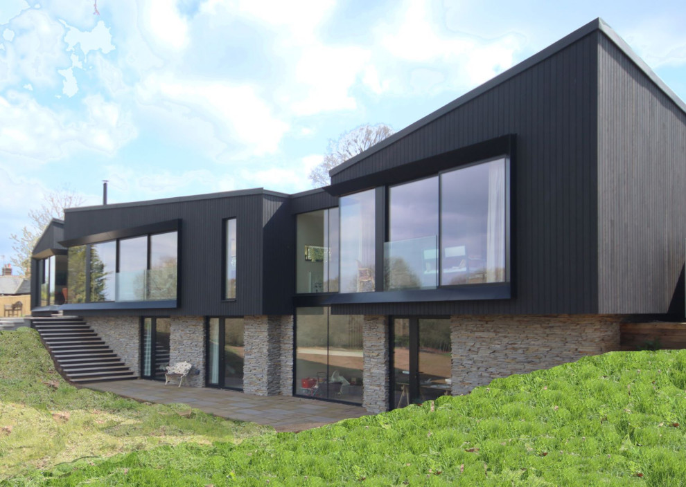 Inspiration pour une façade de maison noire design en bois et planches et couvre-joints de taille moyenne et à un étage avec un toit plat et un toit végétal.