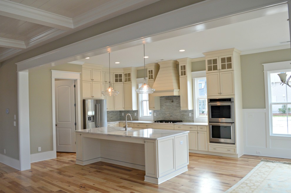 Inspiration for a light wood floor kitchen remodel with a farmhouse sink, stainless steel appliances and an island