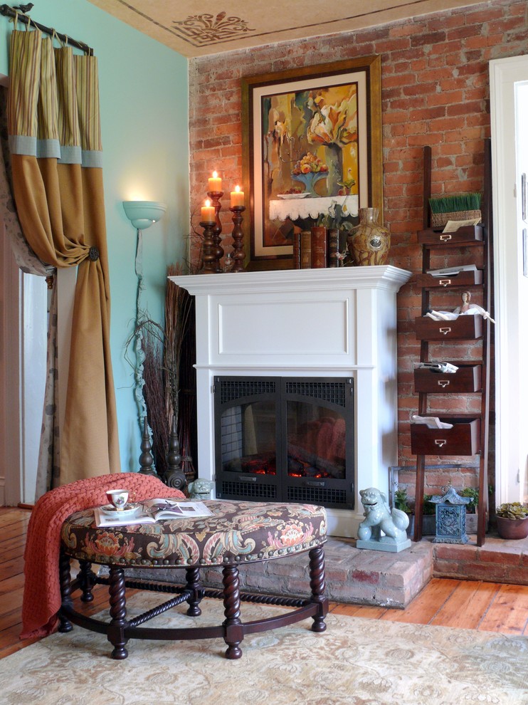 This is an example of a mid-sized eclectic enclosed living room in New York with a library, multi-coloured walls, medium hardwood floors, a standard fireplace, a wood fireplace surround and no tv.