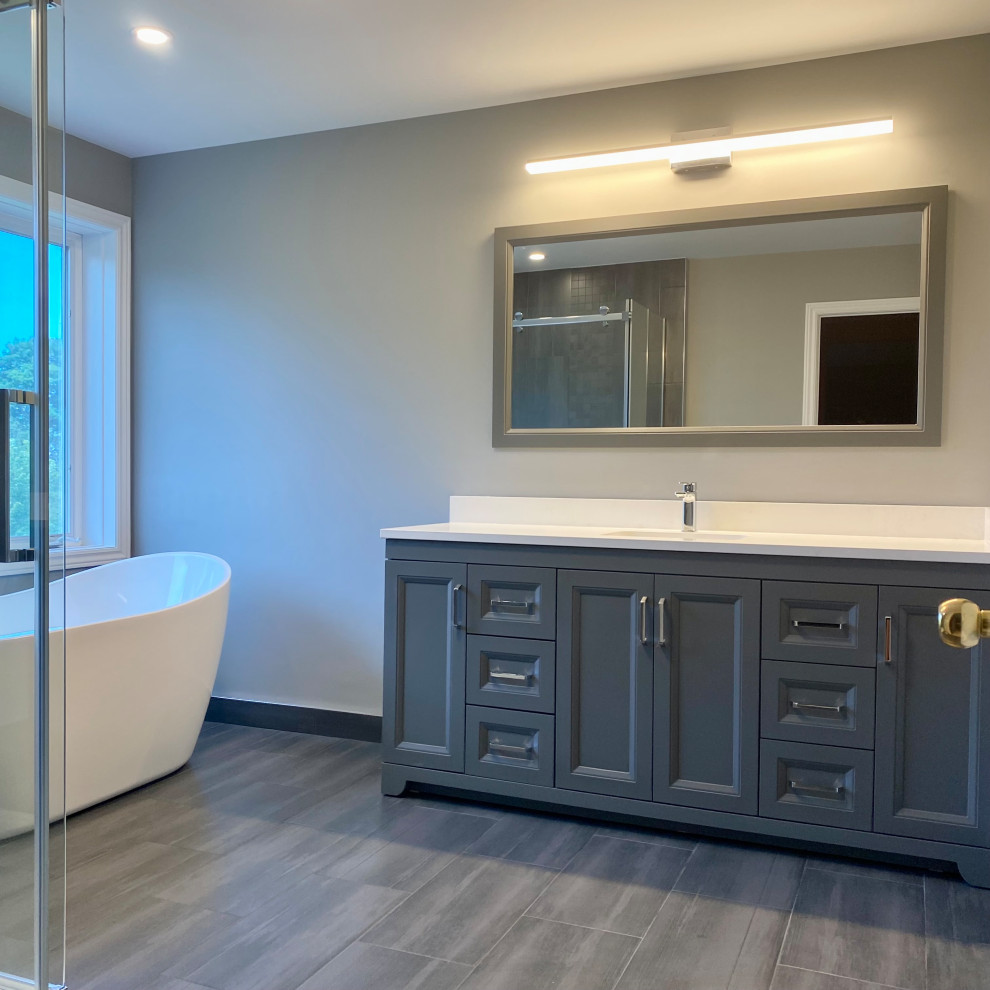Inspiration for a huge transitional master porcelain tile porcelain tile, gray floor and single-sink freestanding bathtub remodel with recessed-panel cabinets, a one-piece toilet, an undermount sink, quartzite countertops, white countertops and a built-in vanity