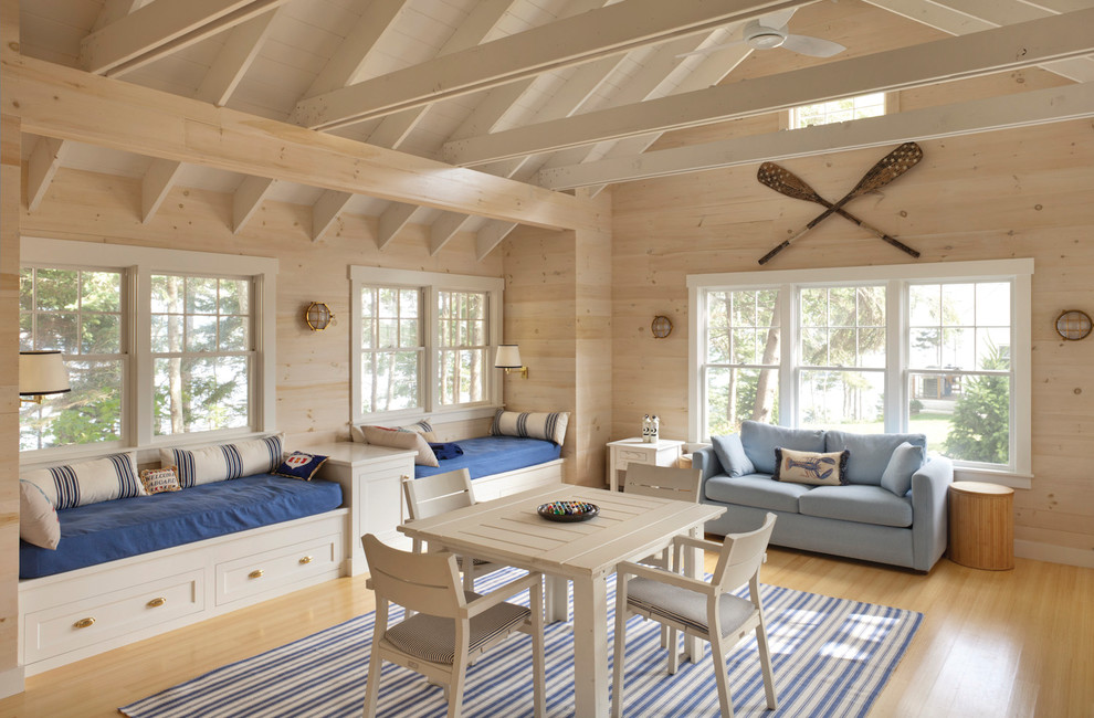 Example of a beach style light wood floor and beige floor family room design in Portland Maine with beige walls