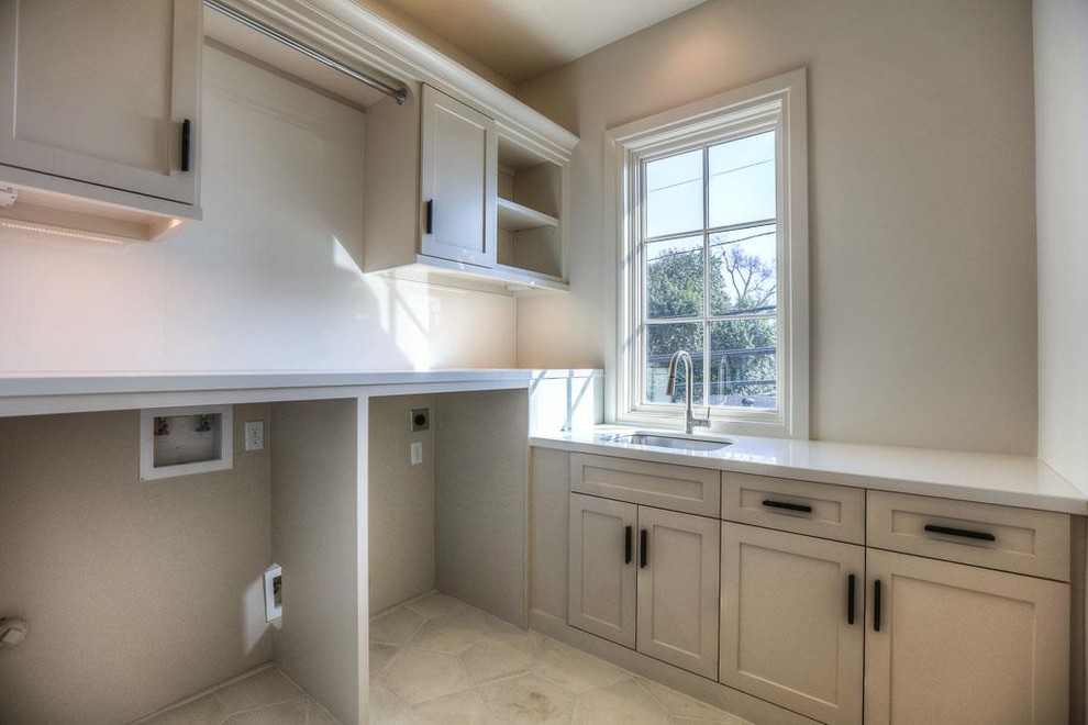 Inspiration for a mid-sized transitional l-shaped kitchen in Houston with an undermount sink, recessed-panel cabinets, white cabinets, solid surface benchtops, white splashback, stainless steel appliances and limestone floors.