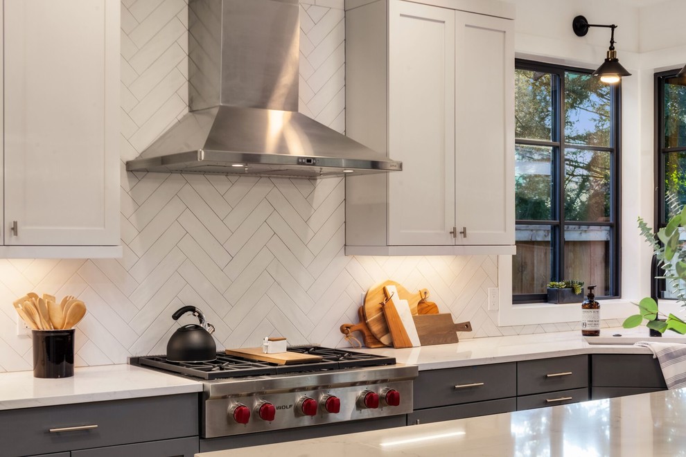 Example of a large transitional l-shaped light wood floor and brown floor eat-in kitchen design in Seattle with an undermount sink, shaker cabinets, gray cabinets, granite countertops, white backsplash, porcelain backsplash, stainless steel appliances, an island and white countertops