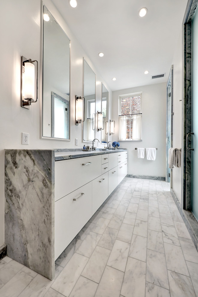 Photo of a transitional bathroom in Charleston with flat-panel cabinets, white cabinets, an alcove shower, white walls, an undermount sink, grey floor, a hinged shower door and grey benchtops.