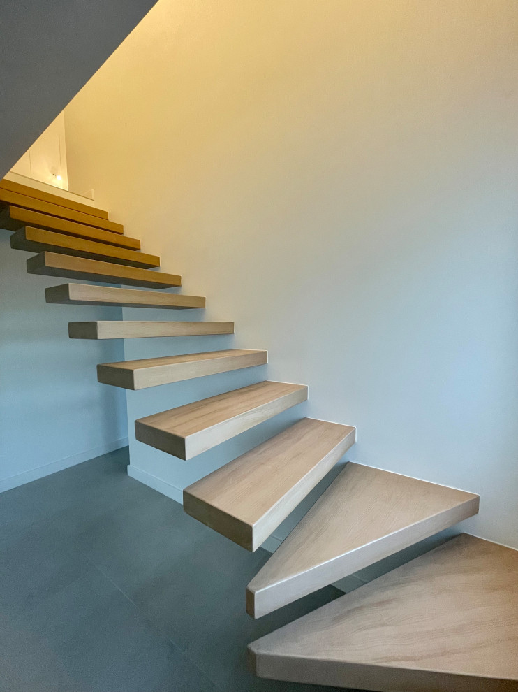 На фото: большая лестница на больцах в современном стиле с бетонными ступенями