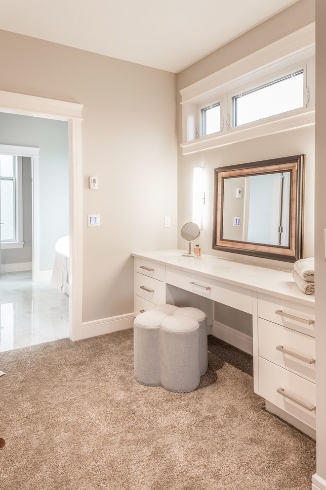 Photo of a mid-sized contemporary women's dressing room in Vancouver with flat-panel cabinets, white cabinets, carpet and brown floor.