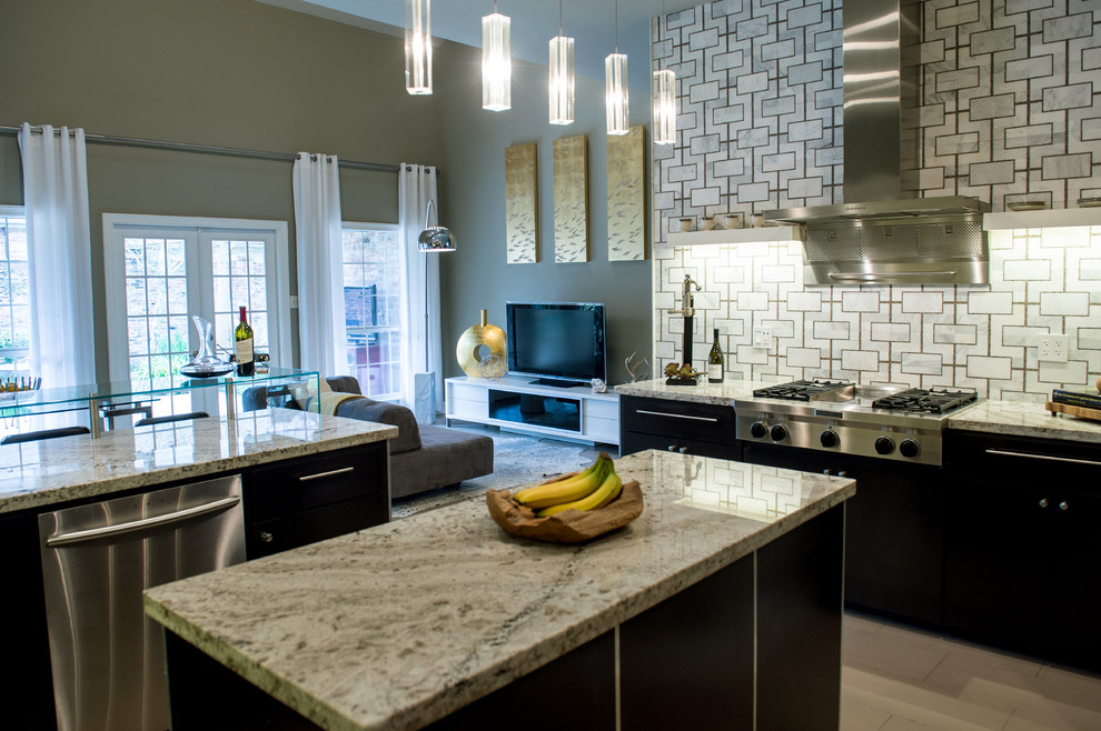 This is an example of a large contemporary u-shaped eat-in kitchen in New Orleans with flat-panel cabinets, black cabinets, granite benchtops, multi-coloured splashback, stainless steel appliances, limestone floors and with island.